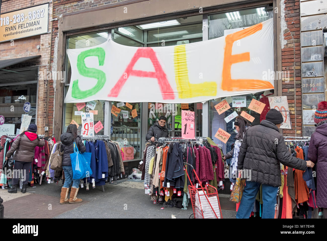 Los compradores venta bajo un enorme cartel fuera de una tienda de ropa de  descuento en 82nd St. off Roosevelt Ave. en Jackson Heights, Queens, Ciudad  de Nueva York Fotografía de stock -