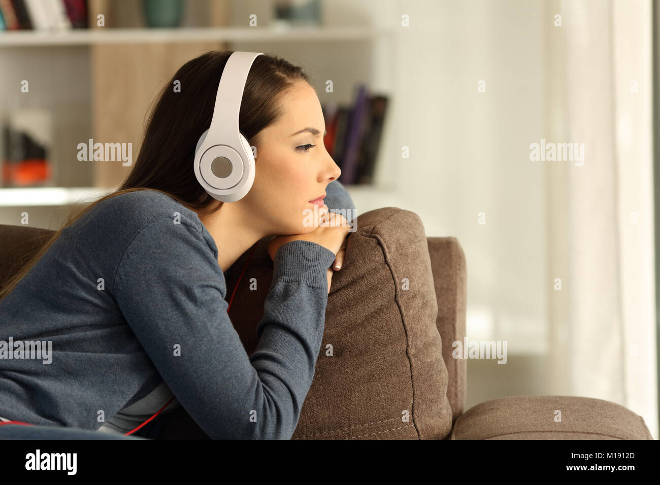 Vista Lateral Retrato De Una Mujer Triste Pensativo Escuchando Musica Sentado En Un Sofa En El Salon De Casa Fotografia De Stock Alamy