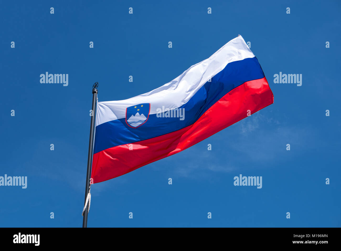Bandera de Eslovenia sobre la bandera ondeando en el viento. Bandera oficial nacional eslovena sobre fondo de cielo azul. Símbolo patriótico, banner Foto de stock