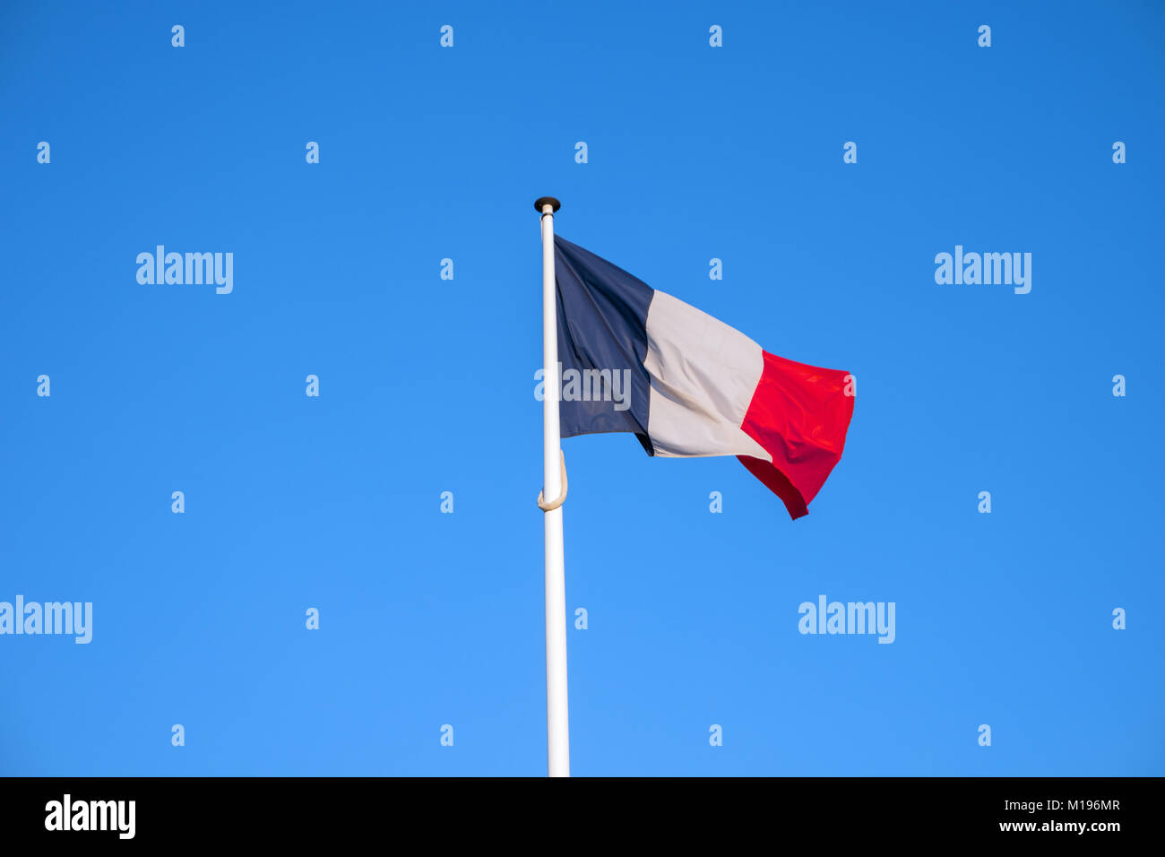 Bandera oficial nacional francesa sobre fondo de cielo azul. Símbolo de Francia. Francés patriótico banner, diseño. Pabellón de Francia sobre la bandera ondeando en el viento Foto de stock