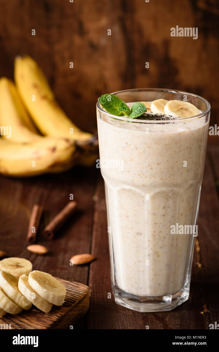 Batido de plátanos en un vaso alto sobre fondo de madera. Vegan bebidas  saludables y nutritivas, sobrealimentación, el gimnasio, la dieta  alimentaria. Concepto de alimentación saludable, die Fotografía de stock -  Alamy