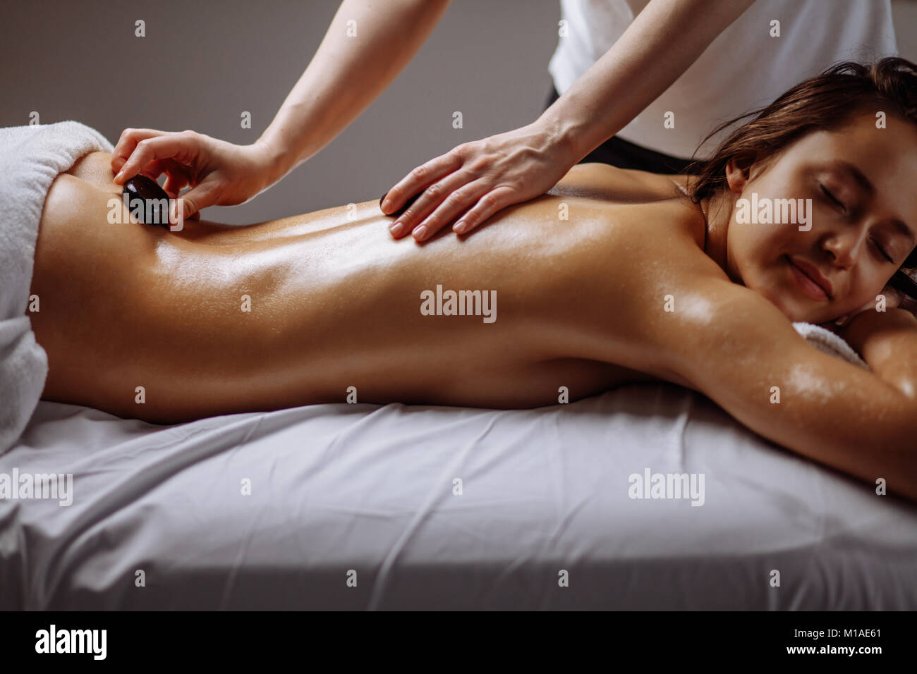 Mujer recibiendo el masaje con piedras calientes en el salón spa. Concepto  de tratamiento de belleza Fotografía de stock - Alamy