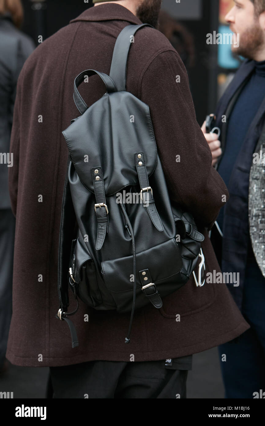 Milán - 15 de enero: el hombre con mochila de cuero negro y marrón capa antes de Pal Zileri Fashion la Semana de la moda de Milán street style el