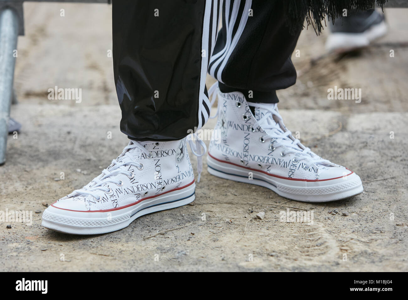 Milán - 15 de enero: el hombre blanco con JW Anderson Converse zapatos y  pantalones adidas negro antes de Fendi Fashion Show, la Semana de la moda  de Milán street style Fotografía