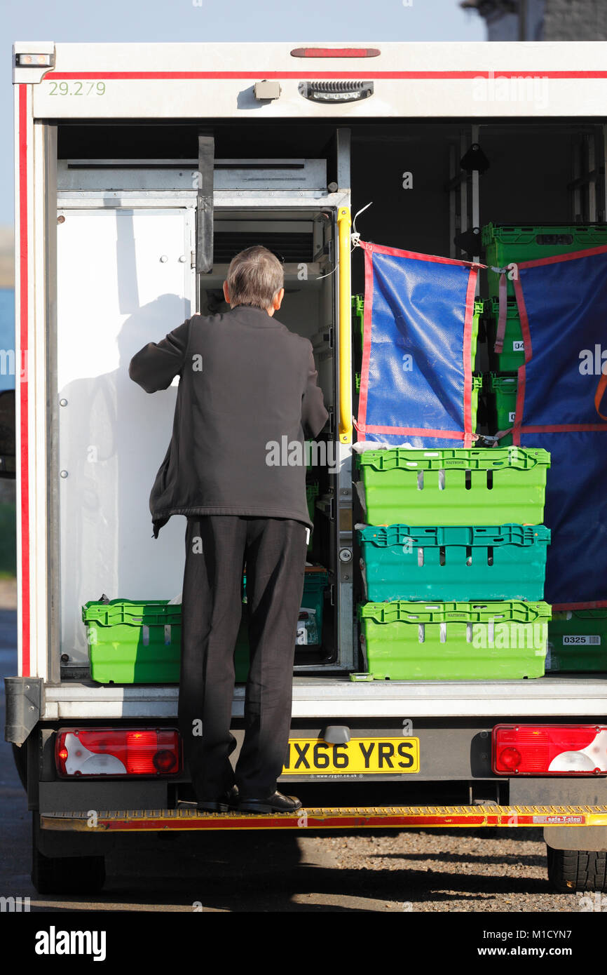 Anciano trabajando desde la parte de atrás de un vehículo de entrega Waitrose. Foto de stock