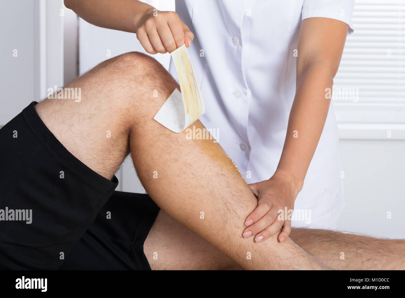 Close-up de un terapeuta depilación con cera de la pierna del hombre de  Gaza Fotografía de stock - Alamy