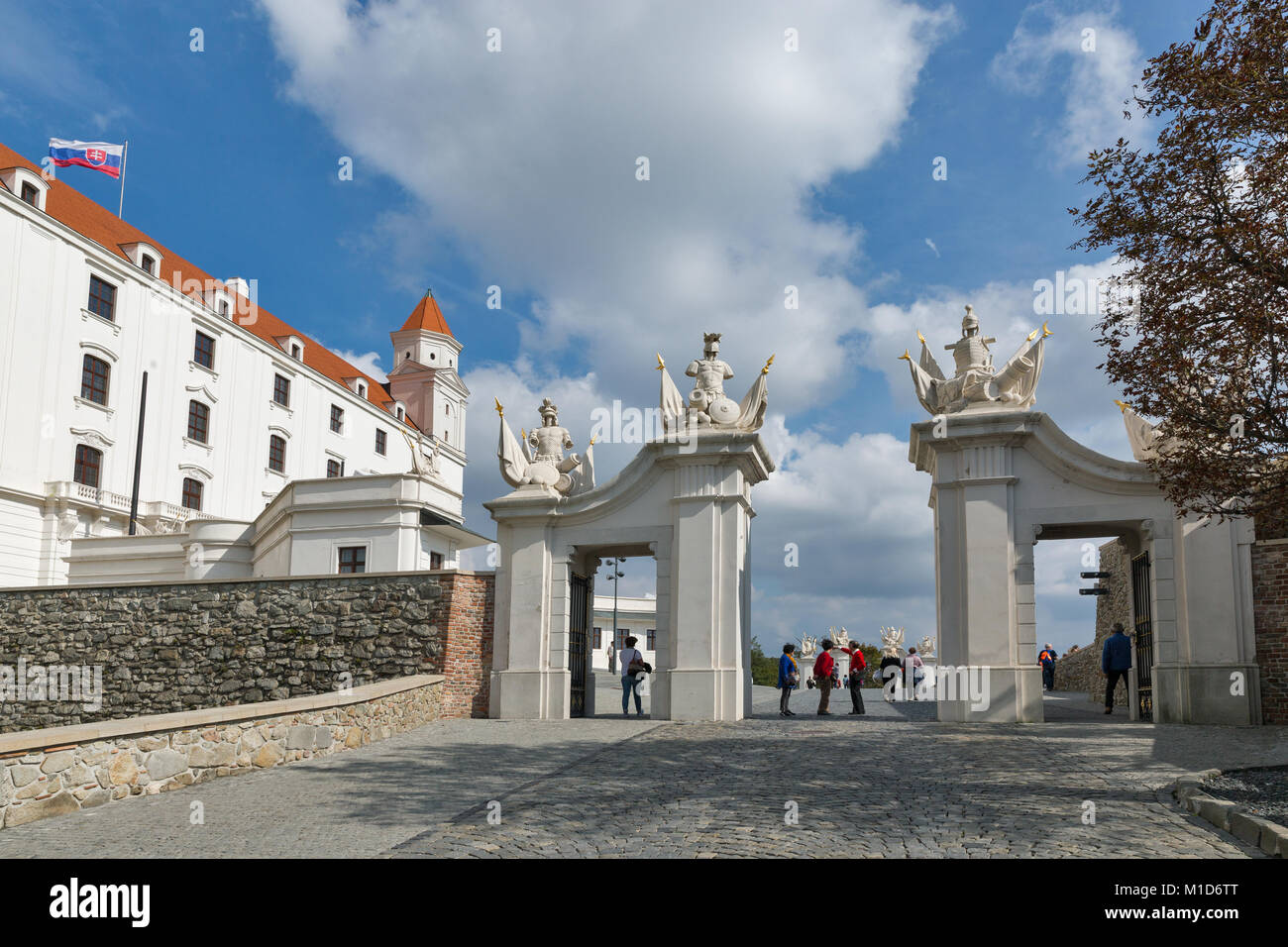 BRATISLAVA, Eslovaquia - Septiembre 25, 2017: los turistas visitan no reconocidos en la puerta delantera del castillo medieval sobre la colina cercana al edificio del Parlamento. Foto de stock