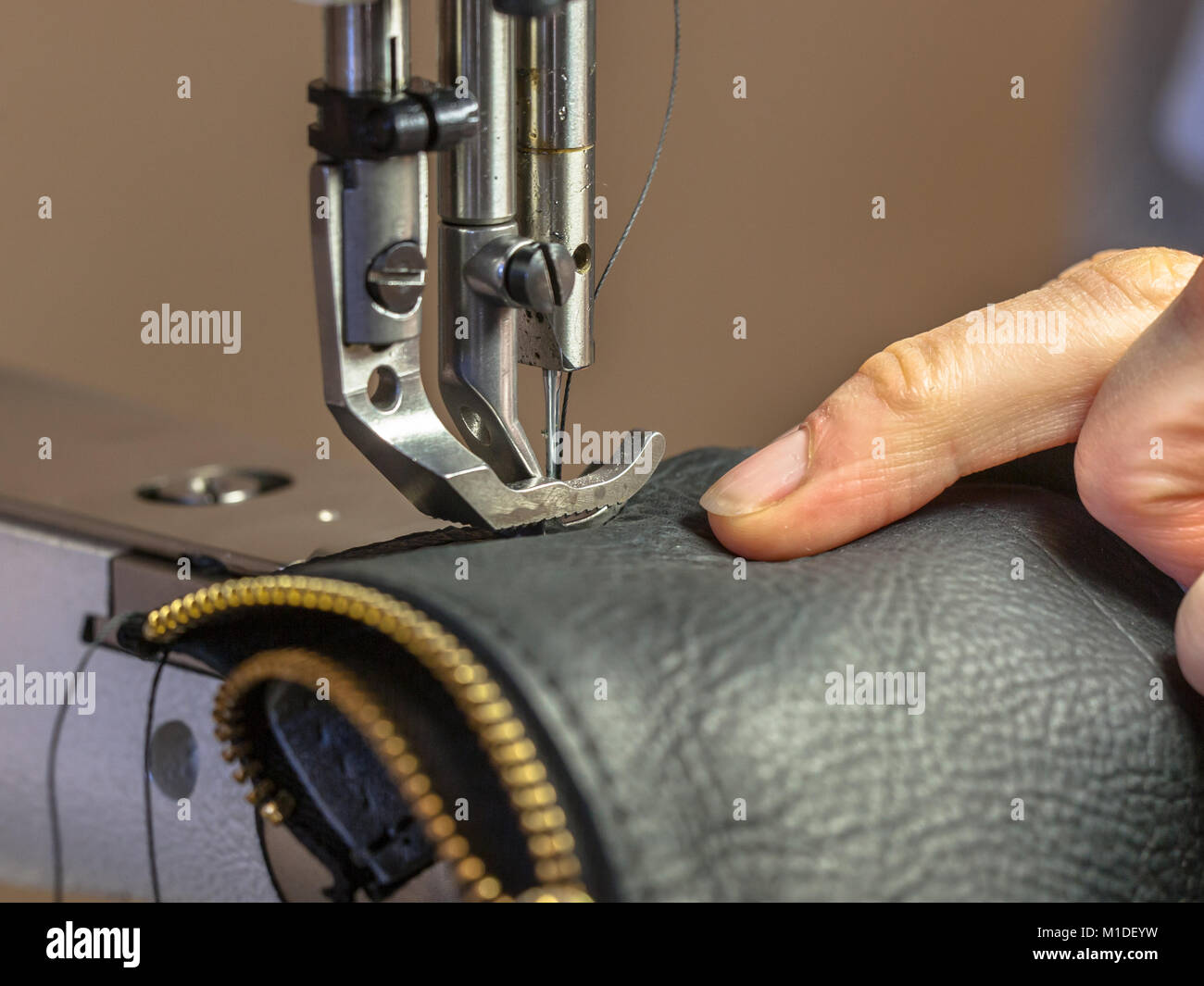 Máquinas de coser industriales en acción con las manos trabajando en prenda  de cuero Fotografía de stock - Alamy