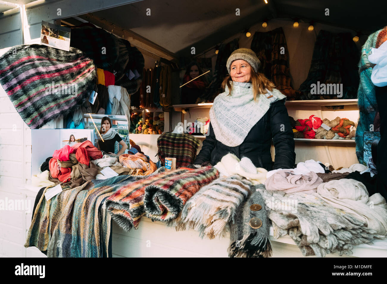Helsinki, Finlandia - 11 de diciembre de 2016: mujer vende bufandas en invierno europeo Mercado de Navidad. Foto de stock