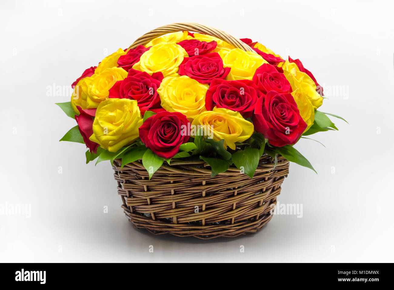 Bouquet de rosas rojas y amarillas en una canasta cerca Fotografía de stock  - Alamy