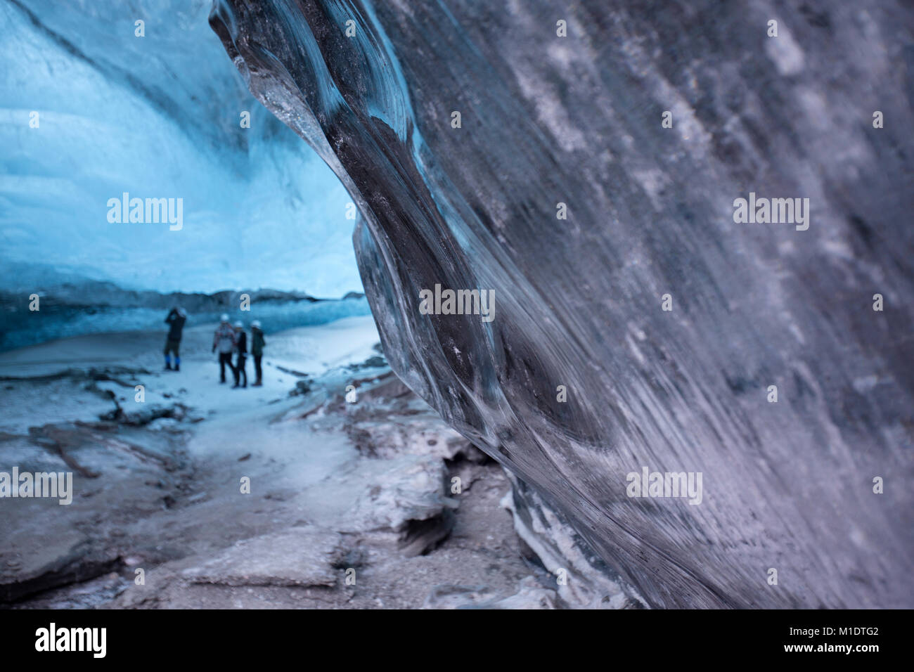 Cueva de hielo en el sureste de Islandia, los turistas con un guía turístico Foto de stock