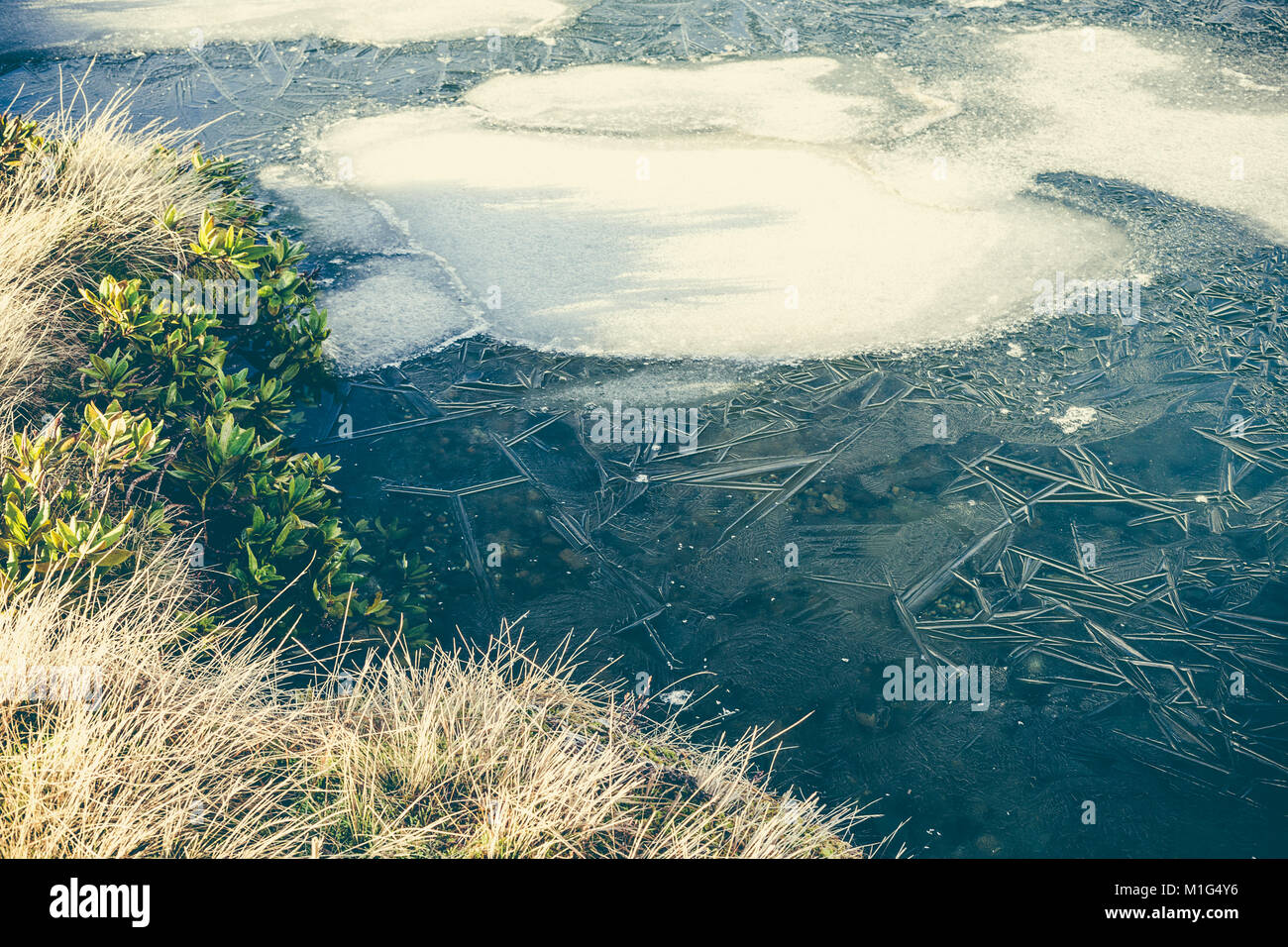 Limpie el agua de un lago de montaña congelado, el concepto de ecología y de agua potable. Foto de stock