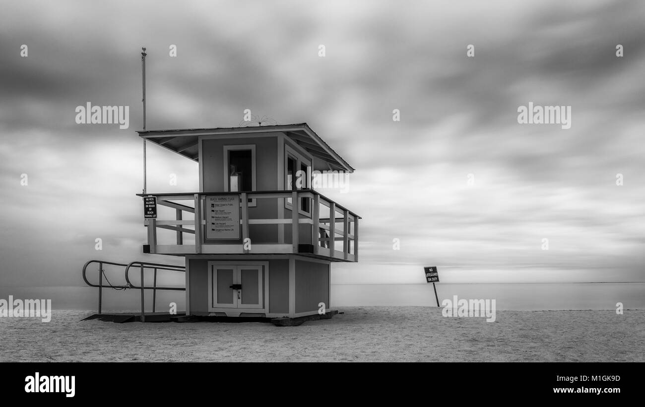 Torre de socorrista en la playa de arena durante el día nublado Tormentoso Foto de stock
