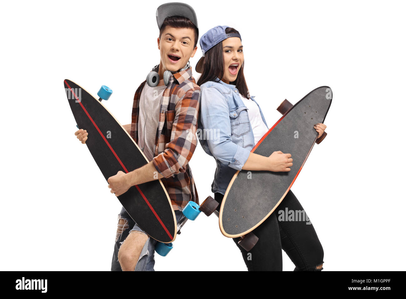 Alegres adolescentes simulando tocar la guitarra en longboards aislado sobre fondo blanco. Foto de stock