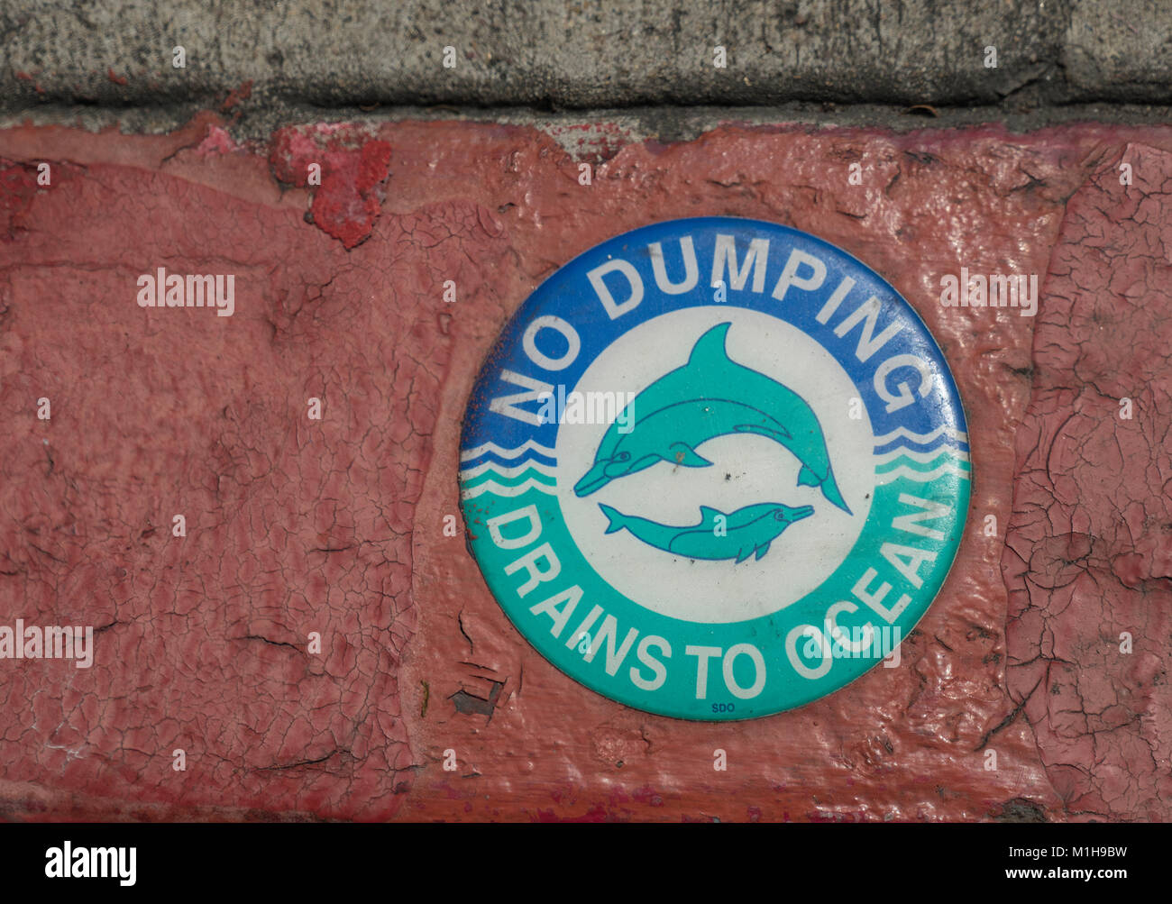 Signo de delfines en un drenaje de tormentas en San Diego â€oeNo Dumping drena al océano. mantener los océanos limpios Foto de stock