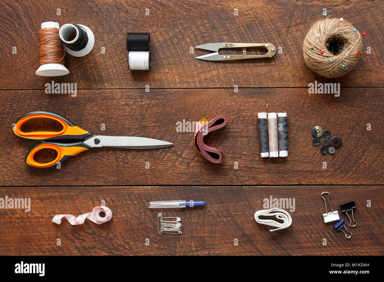 Imagen aérea laicos plana del diseñador de moda artículos concepto de fondo.La vista superior o adaptar accesorios de costura en equipos modernos rústicos de madera marrón en casa Foto de stock