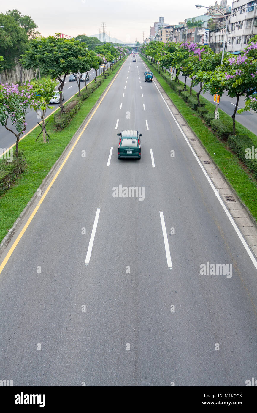 Automóviles circulando por la carretera asfaltada bordeada por árboles, isla de tráfico Huanhe Expressway, distrito de Wanhua, la ciudad de Taipei, Taiwán Foto de stock