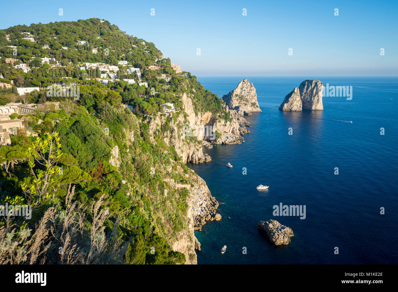 Vista panorámica brillante de los míticos farallones de rocas desde el acantilado trail en la isla mediterránea de Capri, Italia Foto de stock