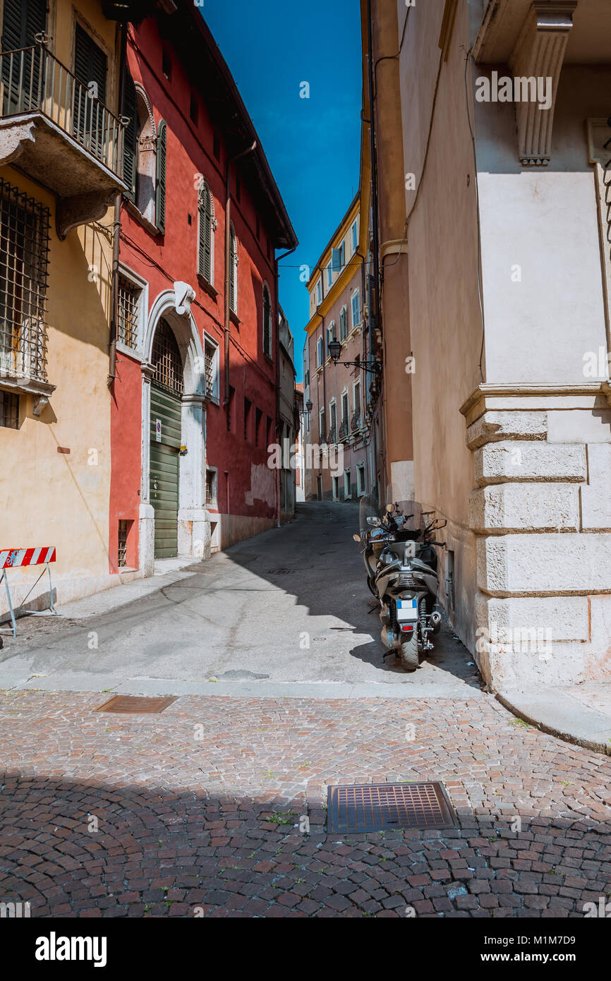 Antigua Calle y motocicletas en la ciudad de Bérgamo, Italia Foto de stock