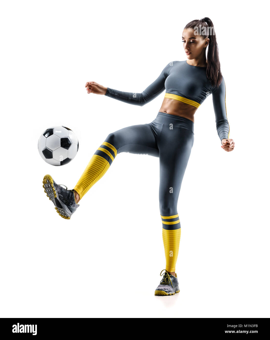 Jugador de fútbol en acción. Foto de mujer deportiva en ropa deportiva aislado fondo blanco. Movimiento dinámico. Foto de stock