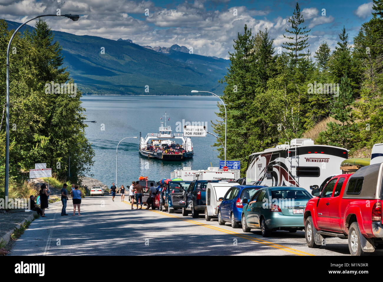 Línea de automóviles esperando para MV Galena para llegar a los lagos de flecha superior de la terminal de ferry en Galena Bay, en el oeste de la región de Kootenay, British Columbia, Canadá Foto de stock