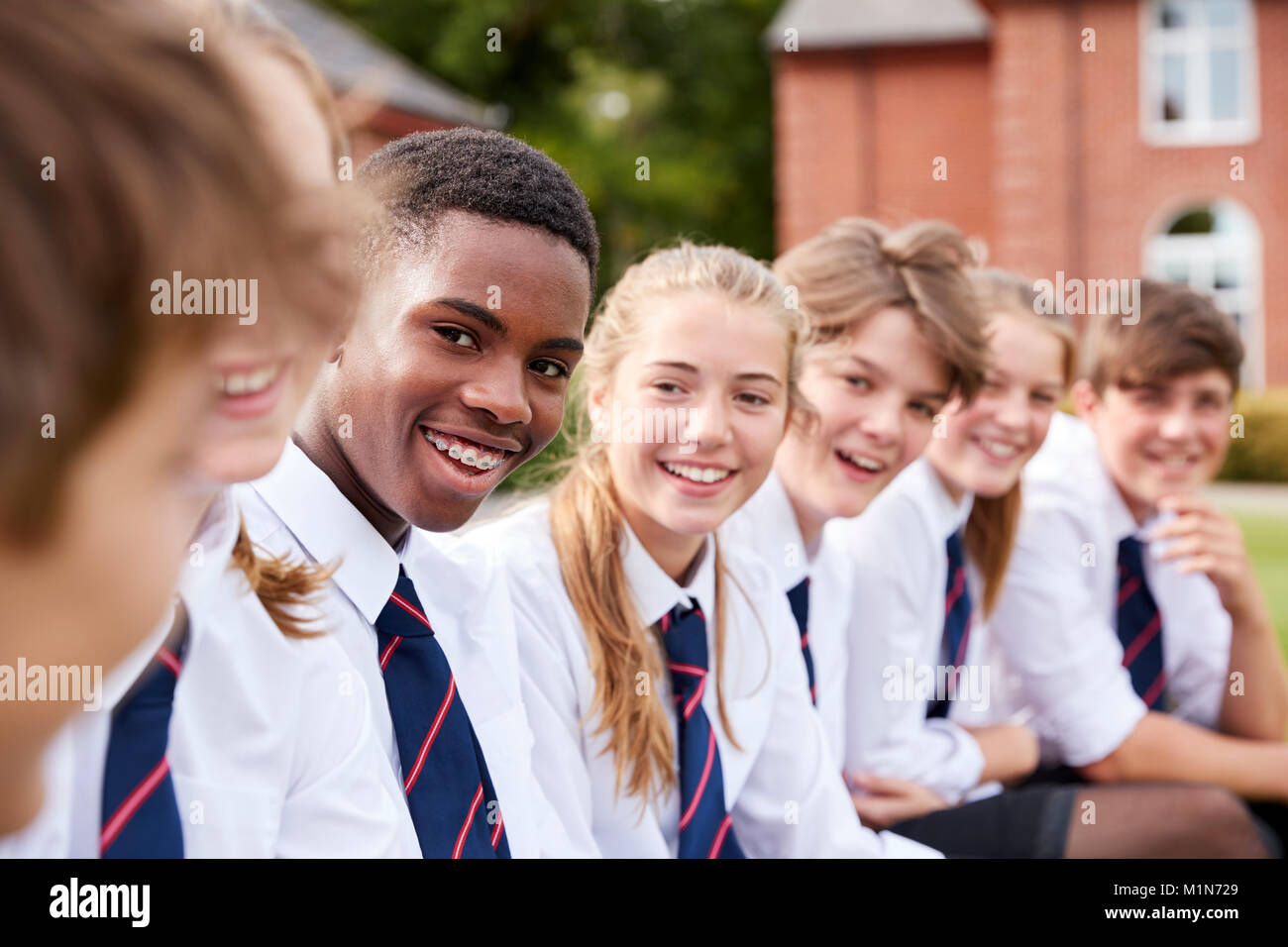 Un grupo de estudiantes adolescentes de uniforme fuera de los edificios escolares Foto de stock