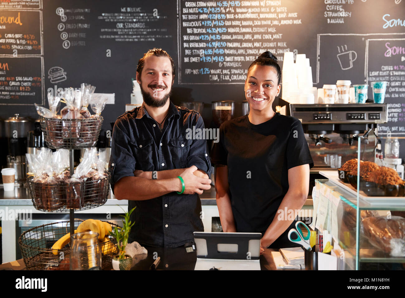 Macho y Hembra Baristas detrás del mostrador en la cafetería. Foto de stock
