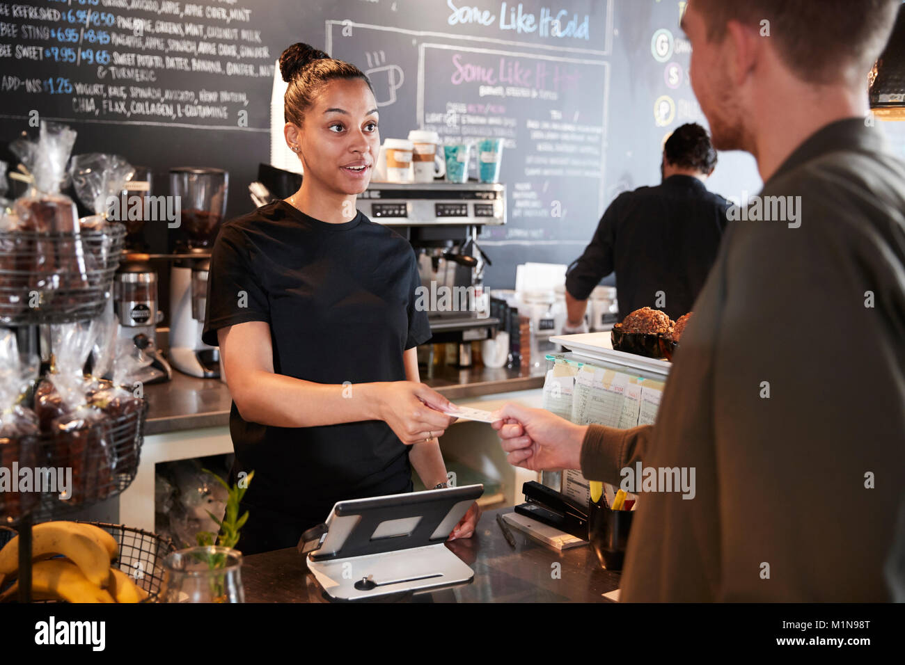 Cliente en la cafetería que pagan con tarjeta de crédito Foto de stock