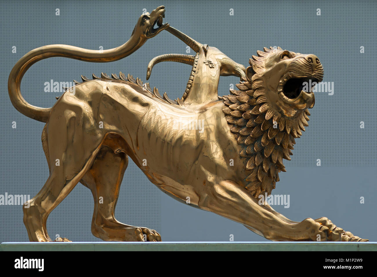  A golden sculpture of a griffin with a snake biting its neck.