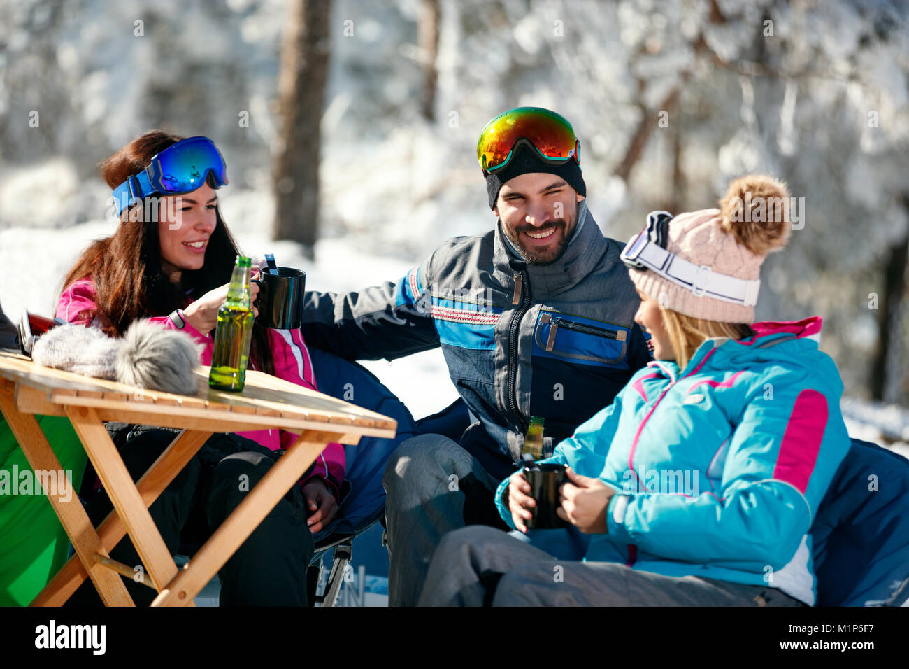 Vacaciones de invierno - grupo de amigos bebiendo cerveza en salto en ski resort Foto de stock