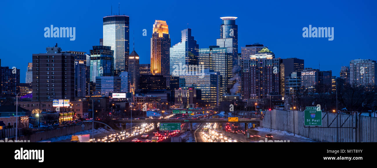 Twilight desciende sobre el centro de Minneapolis, Minnesota, visto desde el sur con la interestatal 35W en primer plano. Foto de stock