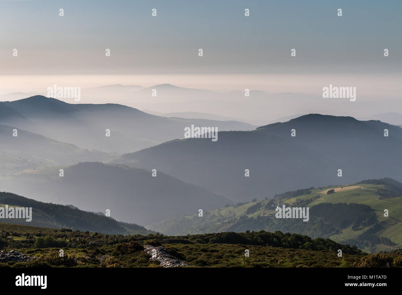 Espectacular atardecer a finales de verano en las montañas del oeste de Asturias, donde el cielo contrasta con la niebla del valle y el color variado Foto de stock
