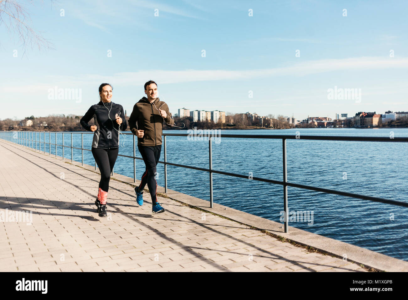 El hombre y la mujer que corre a lo largo de calle en Estocolmo, Suecia Foto de stock