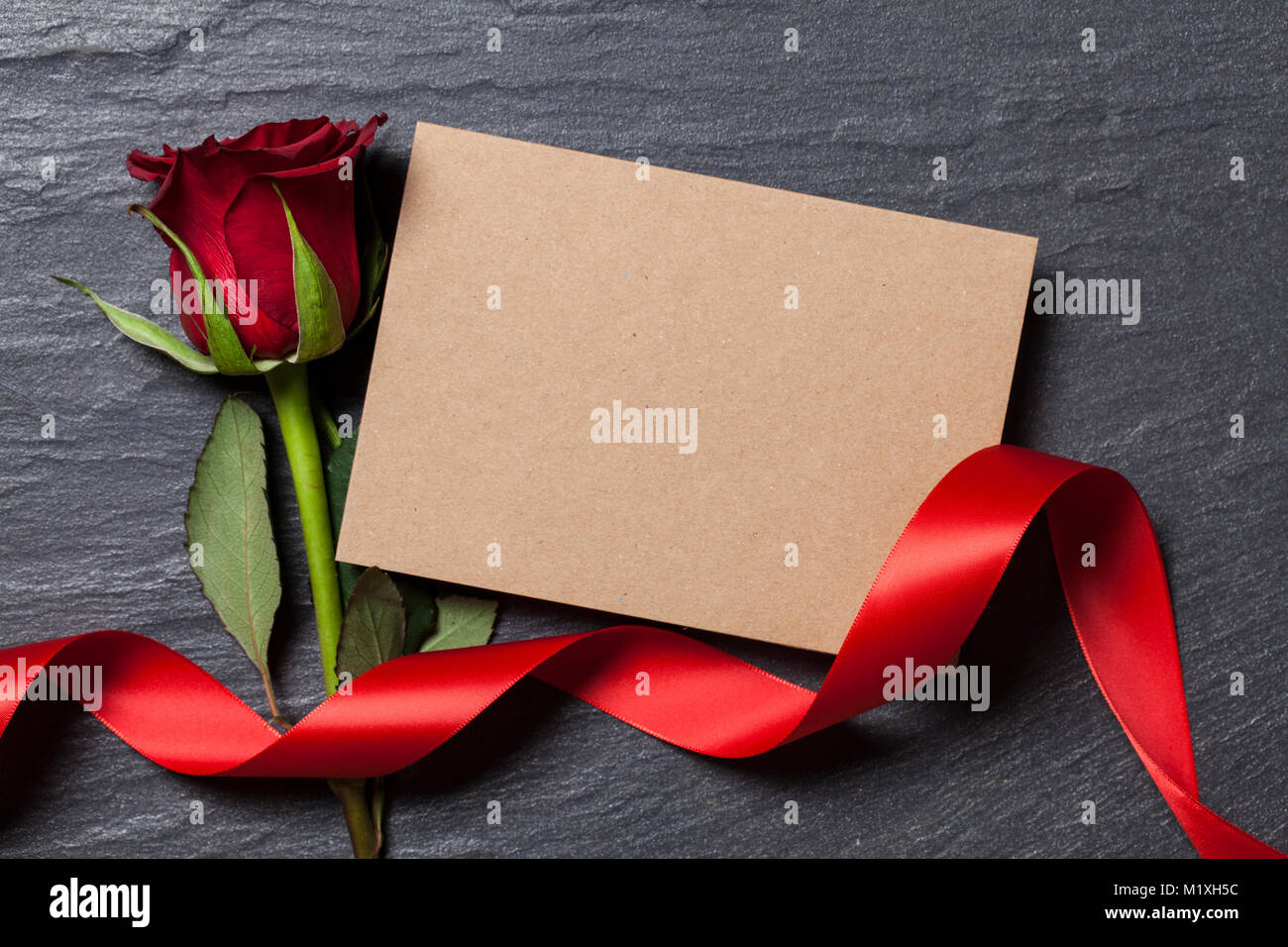 Rosa roja con una tarjeta en blanco para su mensaje Foto de stock