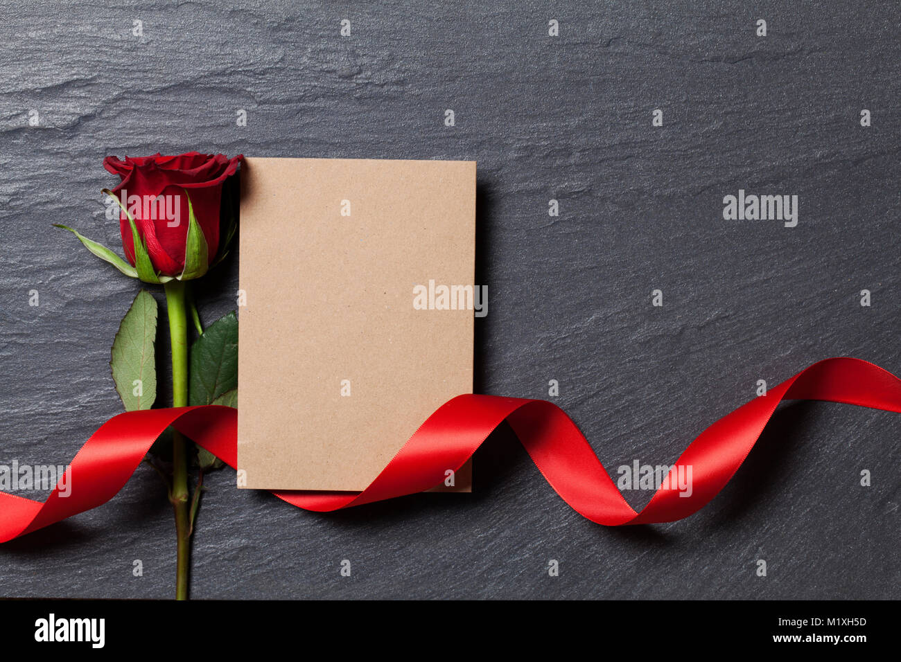 Rosa roja con una tarjeta en blanco para su mensaje Foto de stock