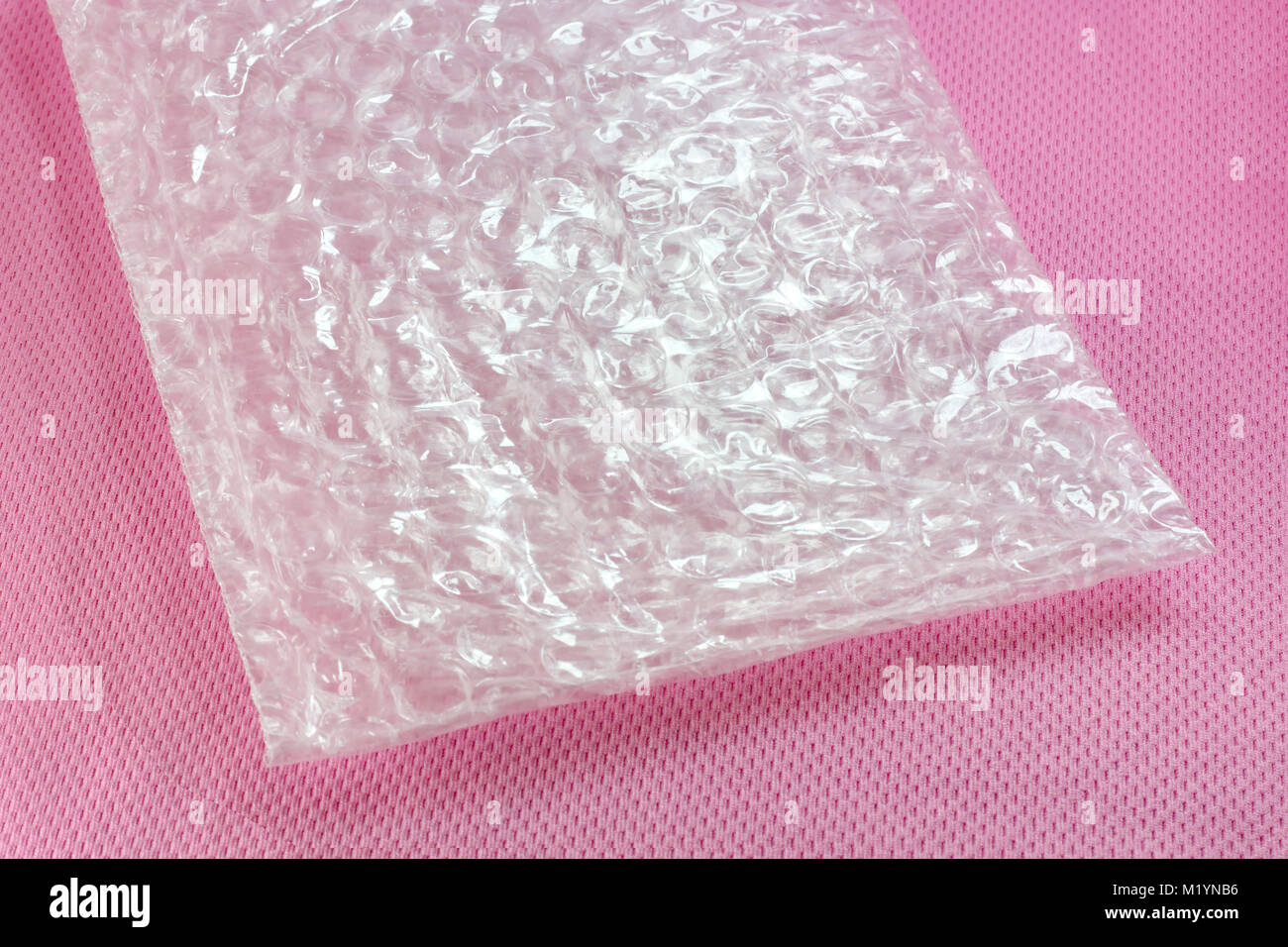 El material a prueba de golpes - Hoja de burbuja de aire sobre fondo de color rosa Foto de stock