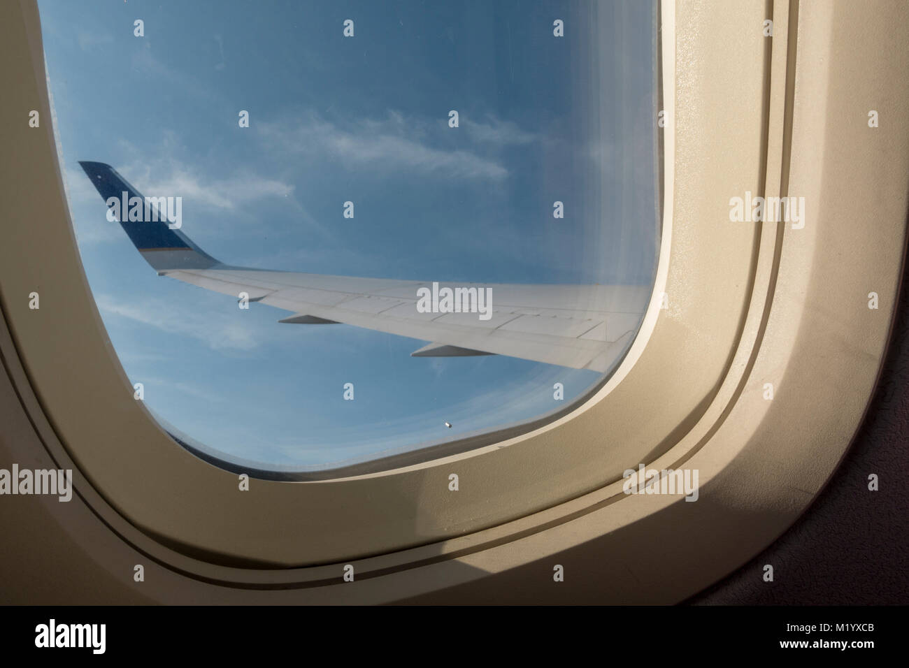 Ver por la ventana de un avión de pasajeros unidos en el cielo nublado por debajo. Foto de stock