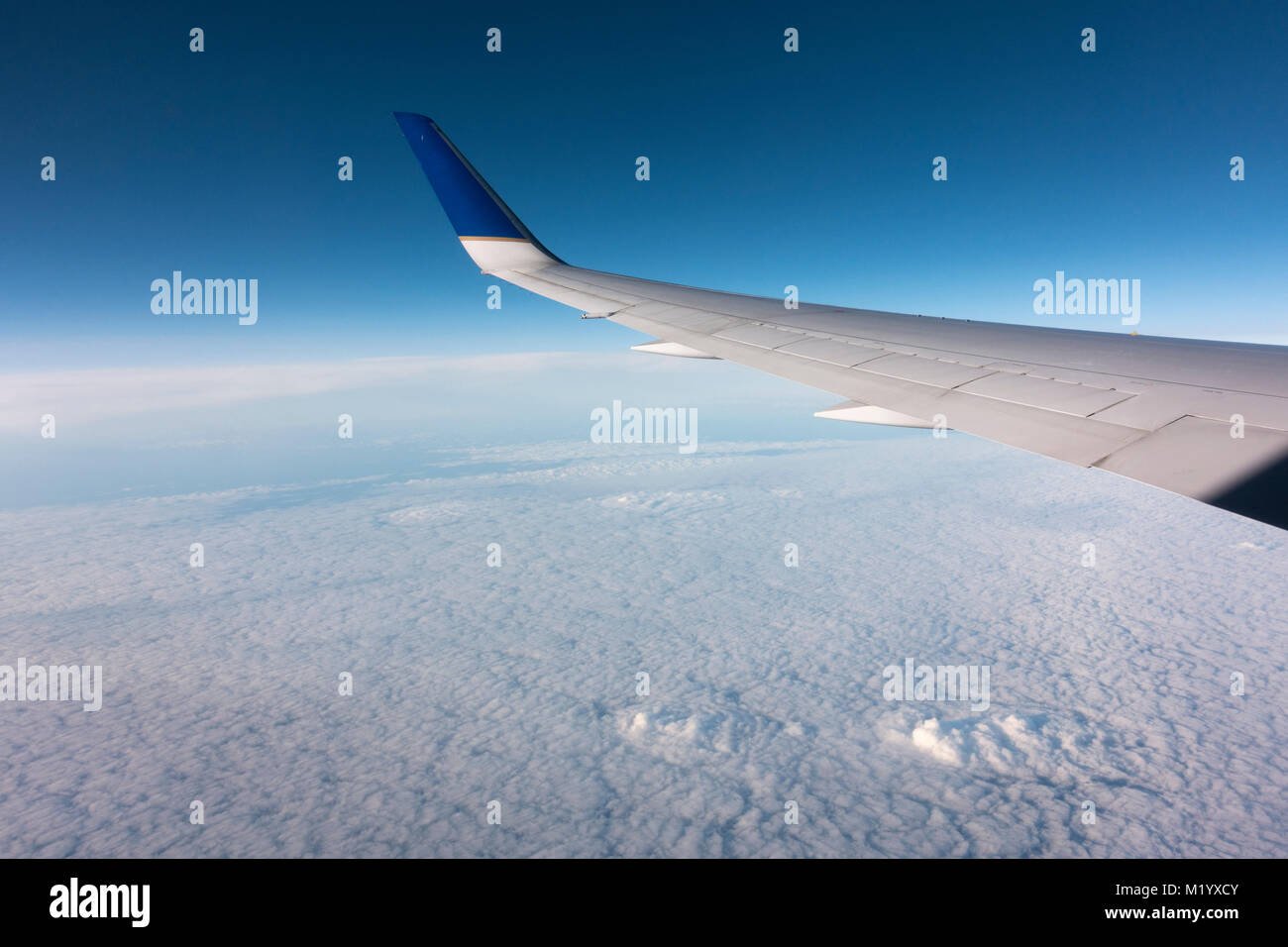 Ver por la ventana de un avión de pasajeros unidos en el cielo nublado por debajo. Foto de stock
