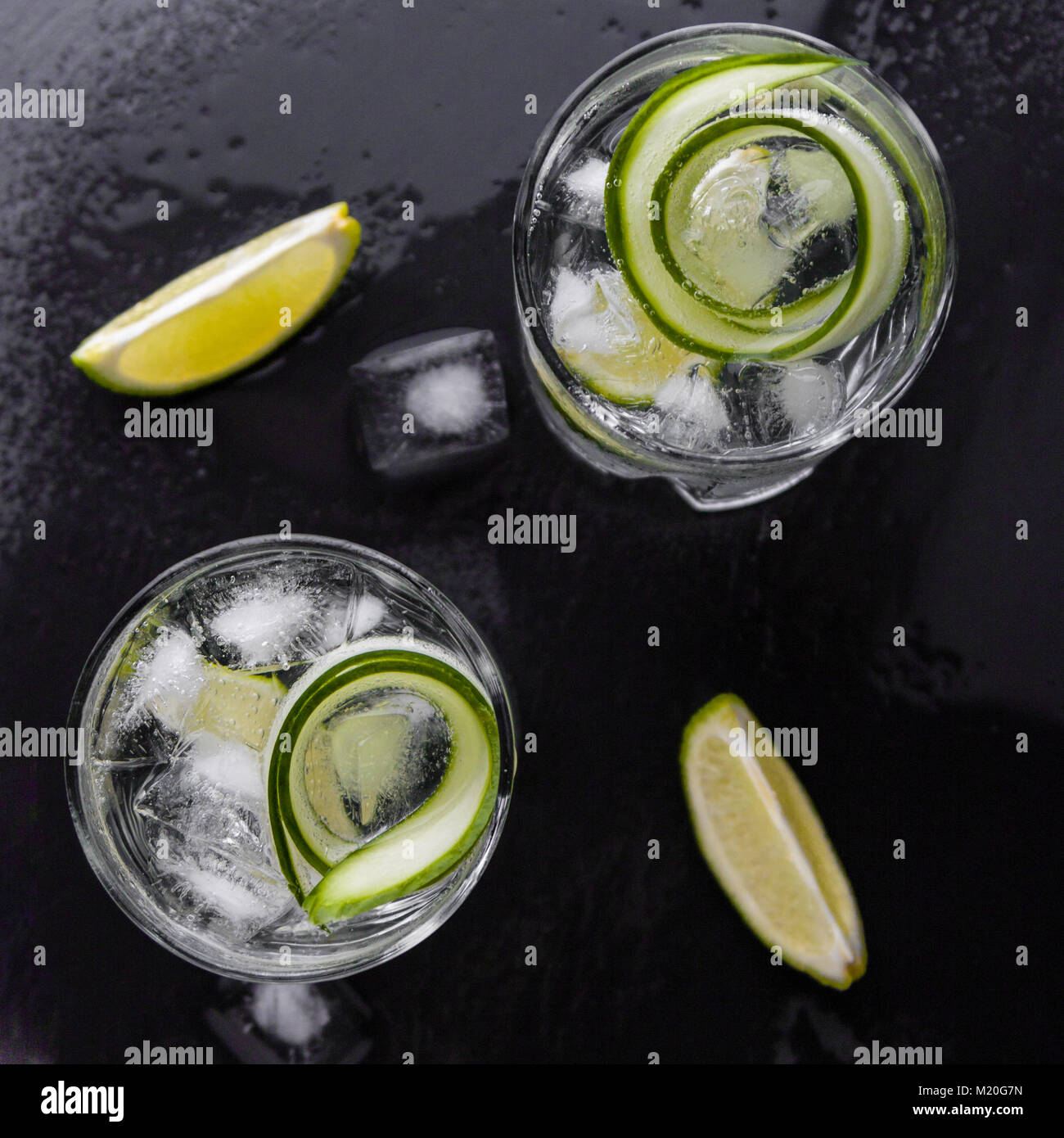 Gin Tonic con pepino, limón y hielo en vidrio Foto de stock