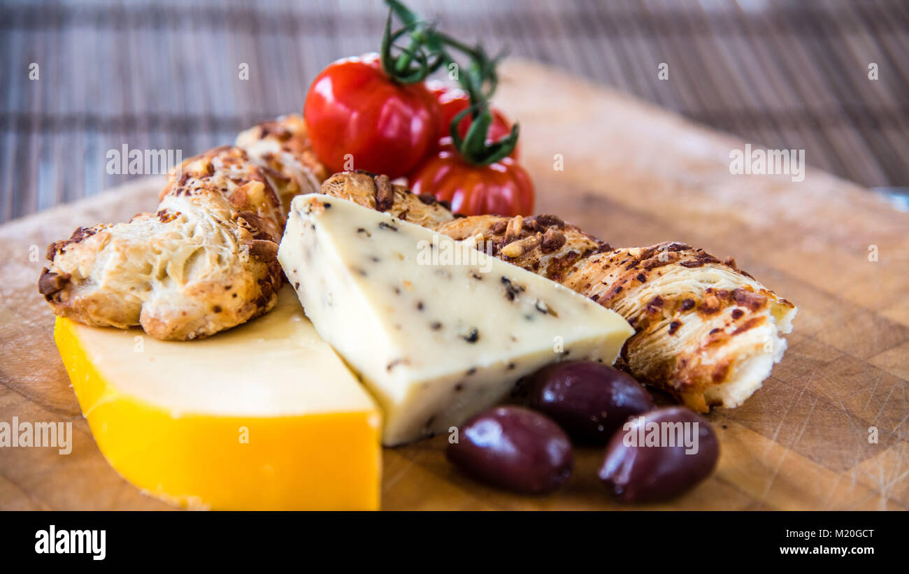 Tabla de quesos, antipasto, aceitunas, tomates marinados y crackers en