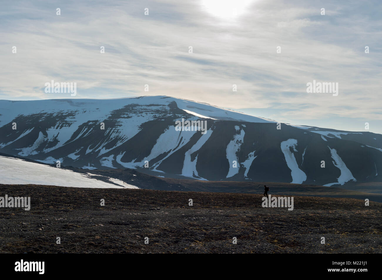 Un hombre solitario senderismo en las montañas del Alto Ártico Foto de stock