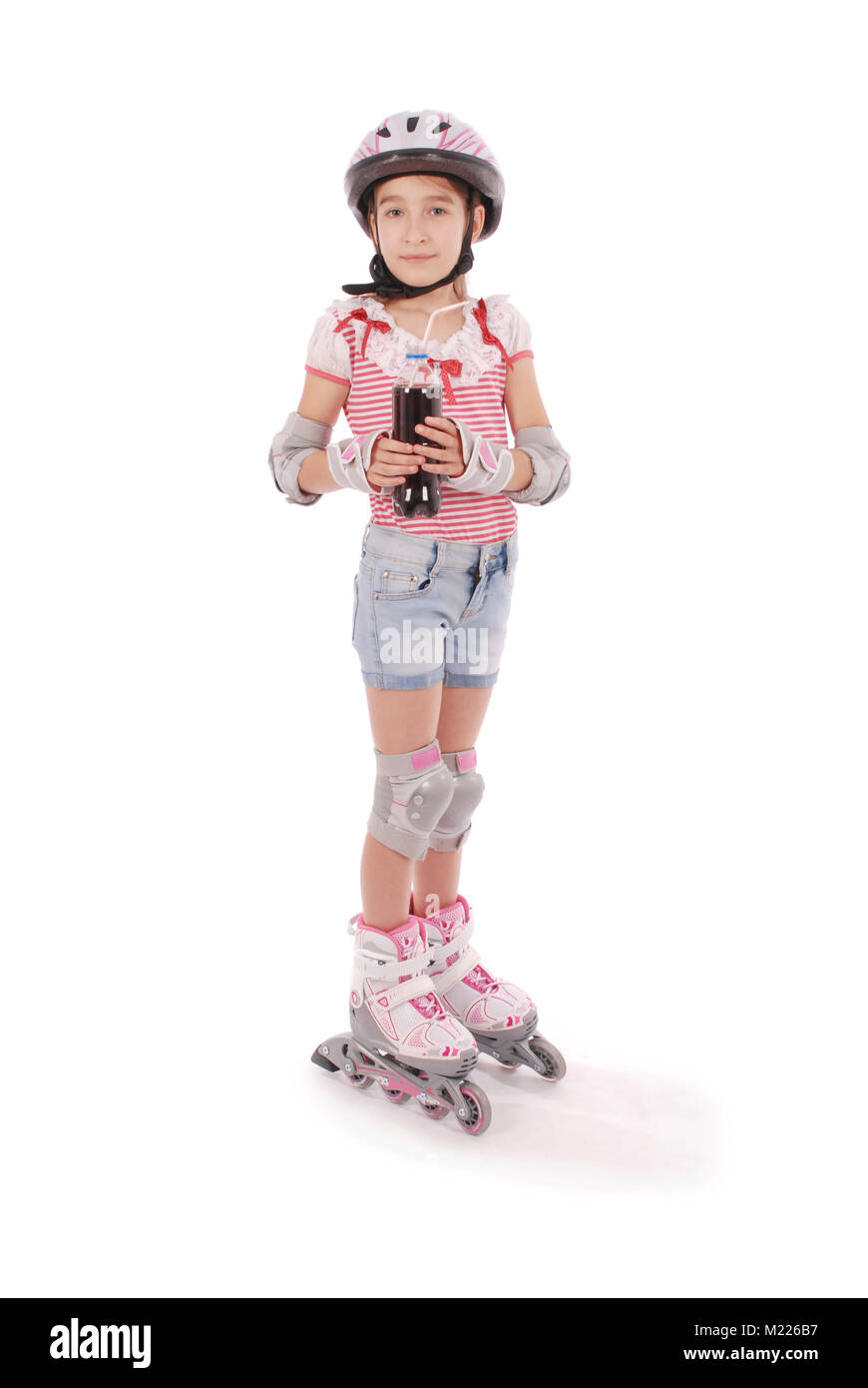 Linda chica en patines contra el fondo blanco. Foto de stock