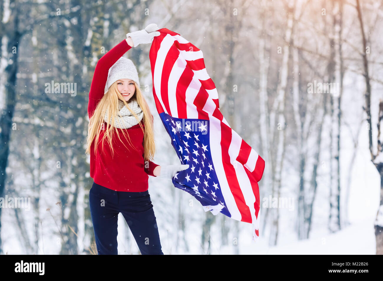 Invierno retrato de adolescente joven chica con la bandera de EE.UU. Belleza alegre niña modelo riendo y divirtiéndose en Winter Park. Hermosa joven al aire libre. Disfrutar de la naturaleza, el invierno Foto de stock