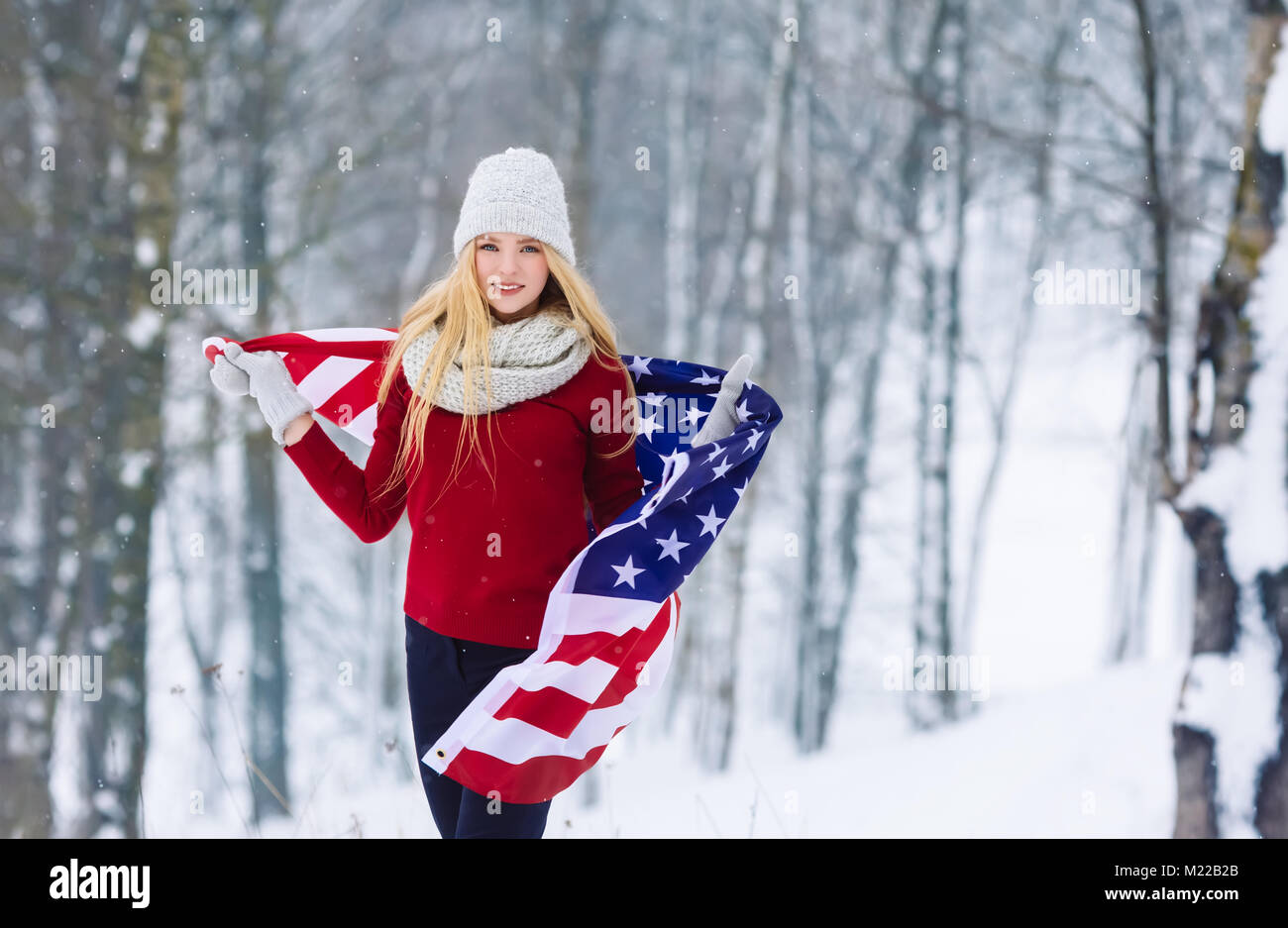 Invierno retrato de adolescente joven chica con la bandera de EE.UU. Belleza alegre niña modelo riendo y divirtiéndose en Winter Park. Hermosa joven al aire libre. Disfrutar de la naturaleza, el invierno Foto de stock