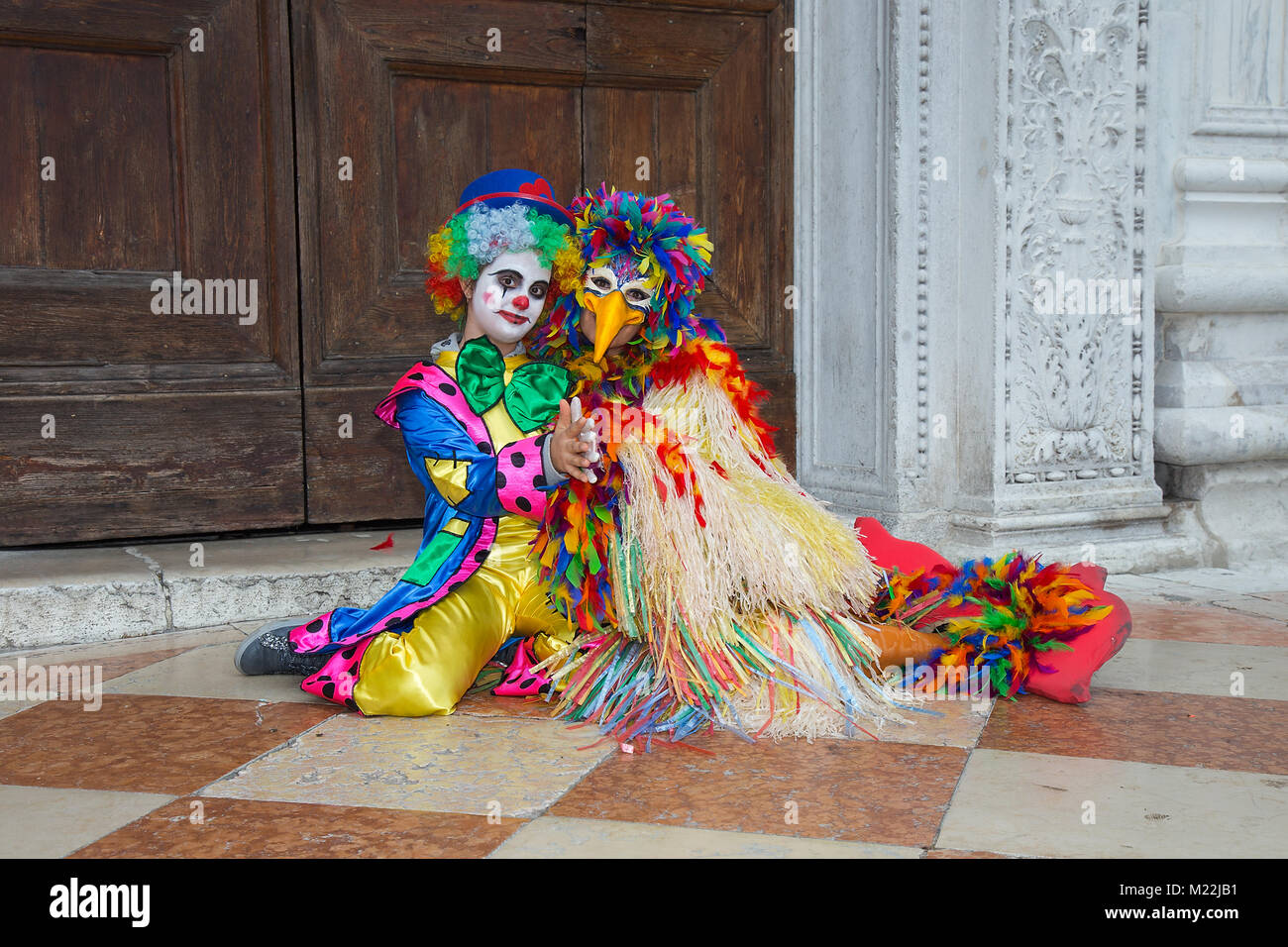 Máscara de payaso en Carnaval de Venecia - Máscara de bufón en un colorido traje en la Plaza de San Marcos en Venecia. Foto de stock
