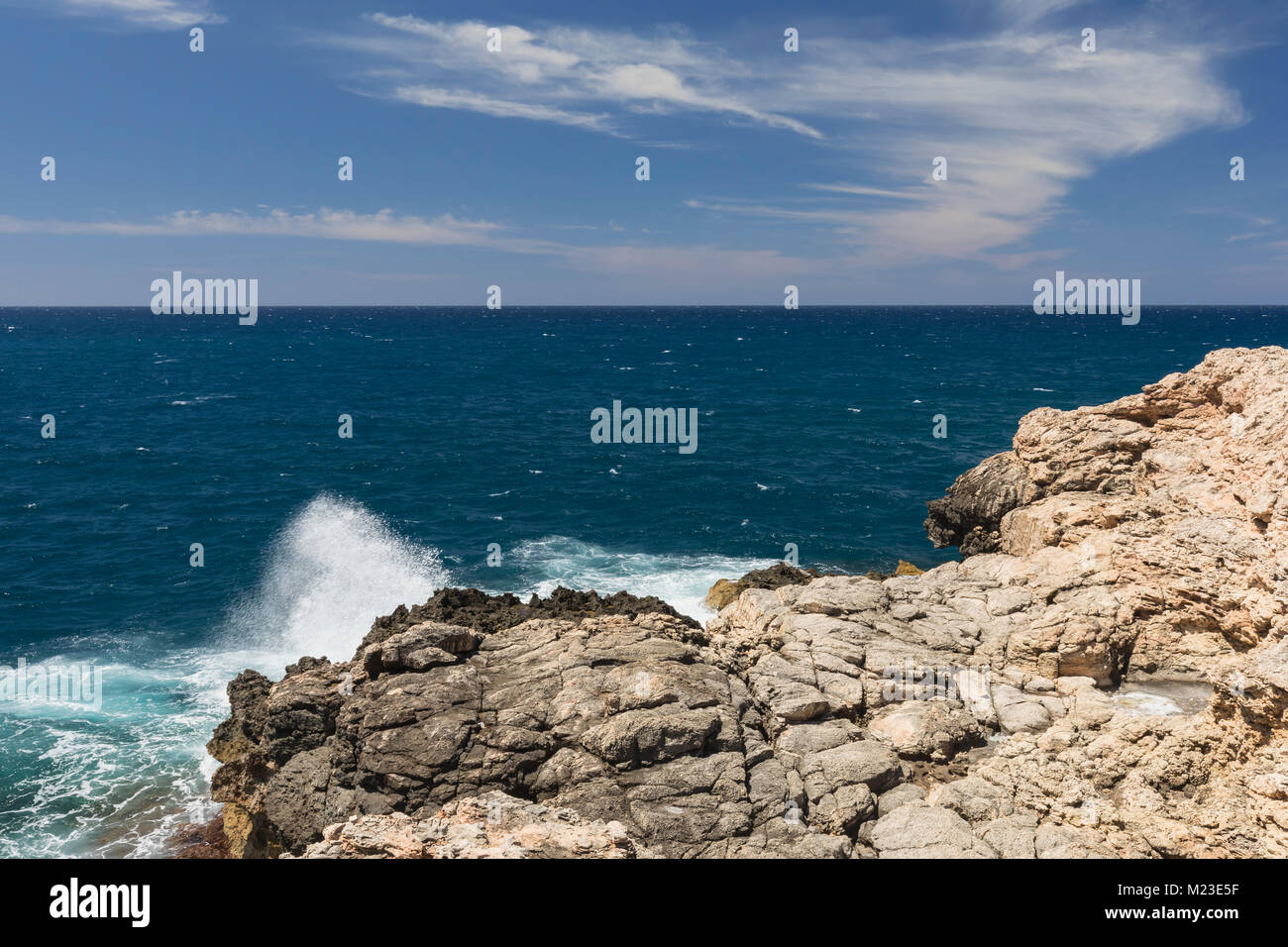 Una imagen que muestra el agua blanca espuma del mar en una costa rocosa shot en Anchor Bay, Malta. Foto de stock