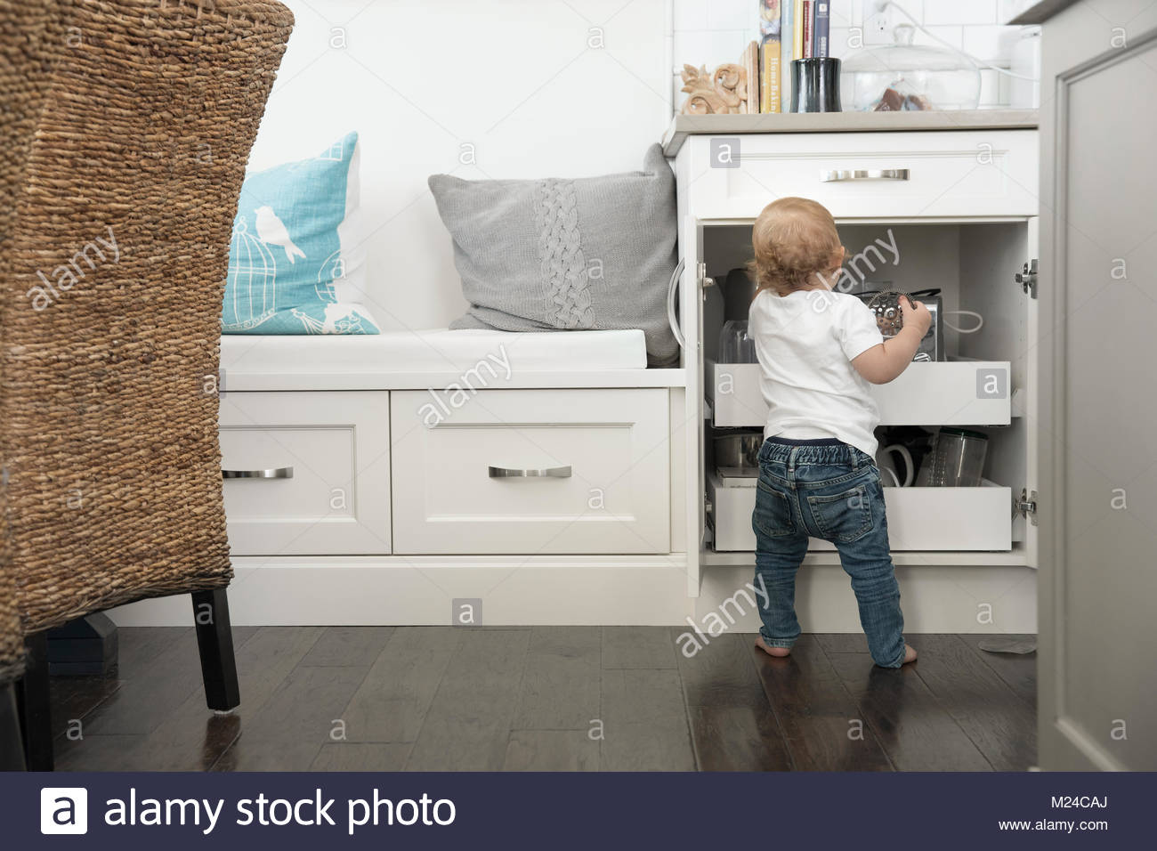 Curioso Baby Boy, llegando en el armario de la cocina Foto de stock
