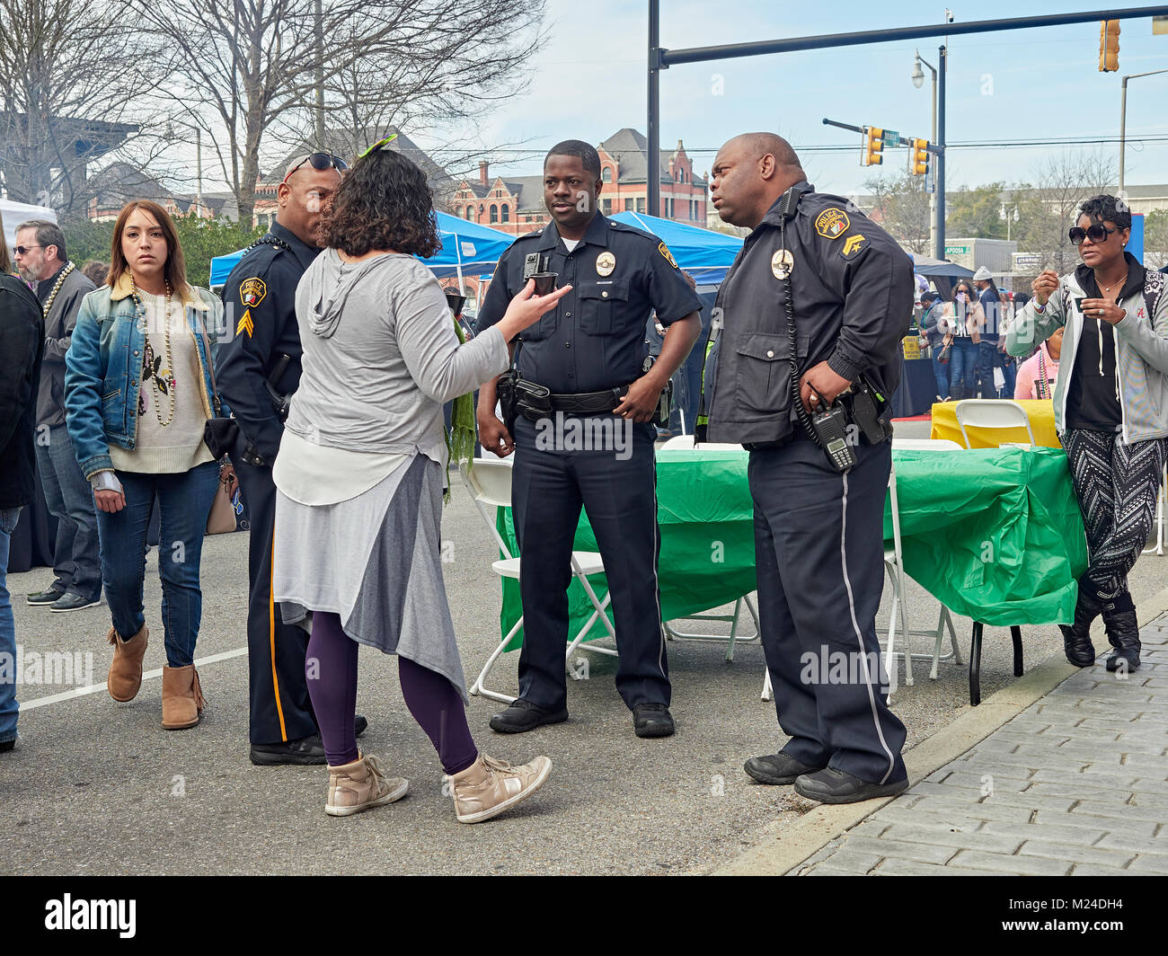 Tres oficiales de policía Afroamericano amablemente hablar con un adulto maduro mujer en una fiesta en la calle Montgomery, Alabama, Estados Unidos. Foto de stock