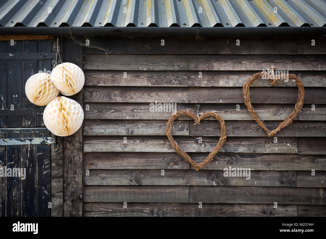 Barn exterior con decorados con adornos de papel y mimbre corazones Foto de stock