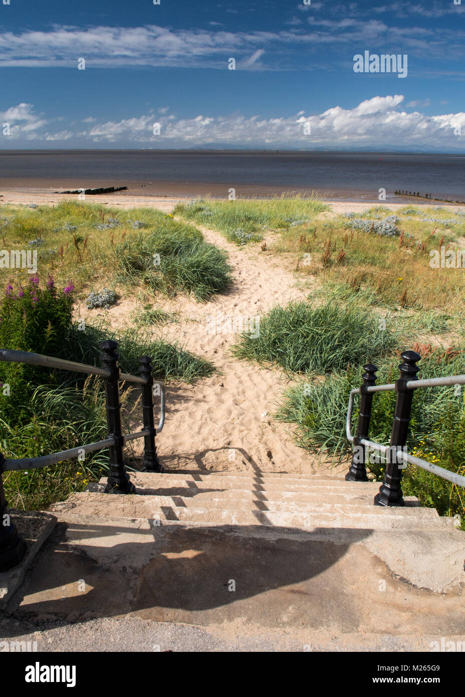 Los pasos que conducen hasta la playa y dunas de arena en Fleetwood, cerca de Blackpool, mirando hacia la bahía de Morecambe, y el Mar de Irlanda. Un camino conduce a través de la s Foto de stock